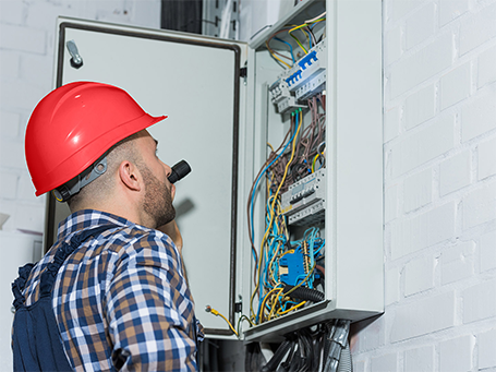 Residential Electrician Checking An Electrical Switchboard With The Help Of A Torch